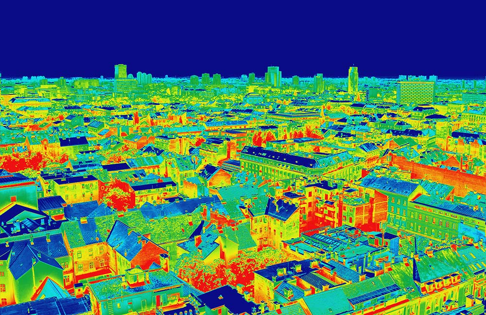 En bild tagen med värmekamera visar energiförluster i en stad.